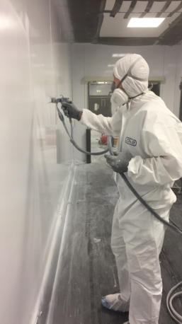Man spraying wall panel