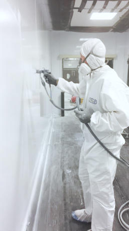 Man spraying wall panel